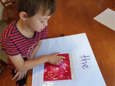 boy using his fingers to spell