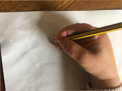 Child's hand holding a pencil with a tripod grip