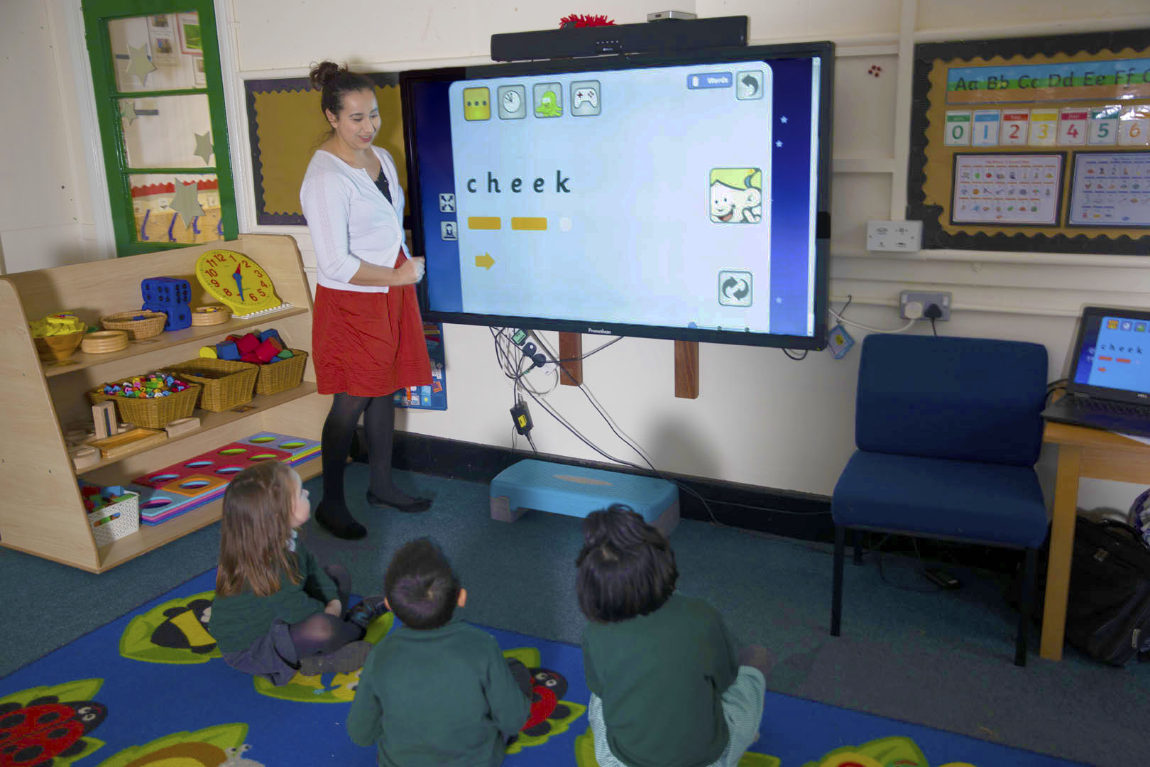 Teacher showing students 'cheek' Phonics on whiteboard