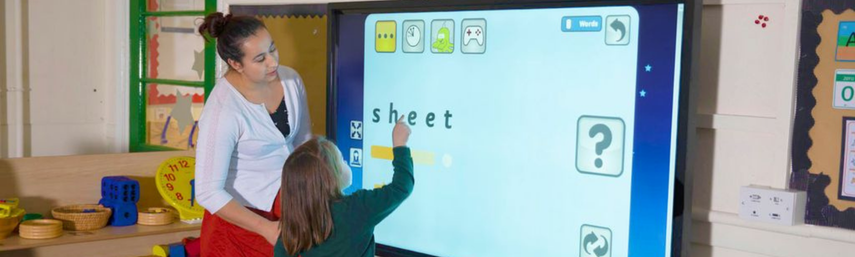 A teacher and student looking at the smartboard